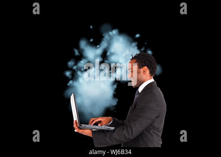 Composite image of smiling businessman working on laptop Stock Photo