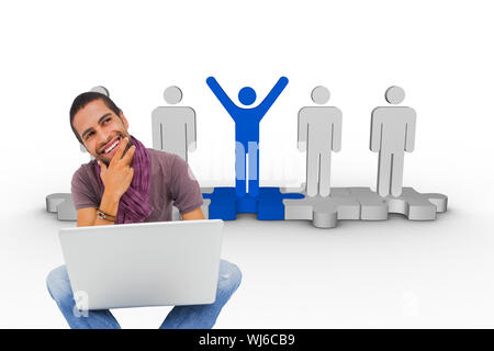 Composite image of thinking man sitting on floor using laptop and smiling on white background Stock Photo