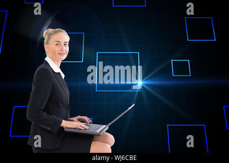Composite image of blonde businesswoman using laptop Stock Photo