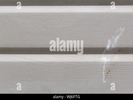 Close view of painted aluminum siding with bird droppings. Stock Photo