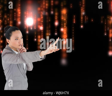 Composite image of unsmiling thinking asian businesswoman pointing Stock Photo