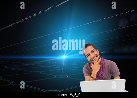 Composite image of thinking man sitting on floor using laptop and smiling Stock Photo