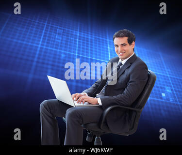 Composite image of portrait of a young businessman sitting on an armchair working with a laptop Stock Photo