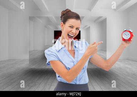 Composite image of businesswoman indicating alarm clock with finger Stock Photo