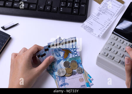 Tenge at the cashier accountant in the hands of the workplace in the office. The cashier counts the money KZT in the workplace in Kazakhstan.