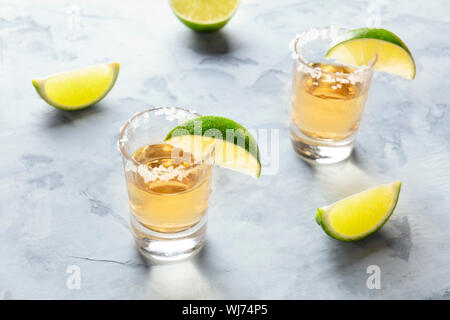 Golden tequila shots with lime slices and salt Stock Photo