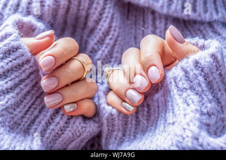 Art nail manicure for bride in purple sweater. Gel nails in soft purple color Stock Photo