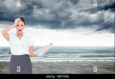 Composite image of shocked classy businesswoman holding newspaper while posing Stock Photo