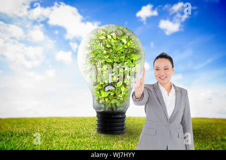 Composite image of smiling asian businesswoman pointing Stock Photo