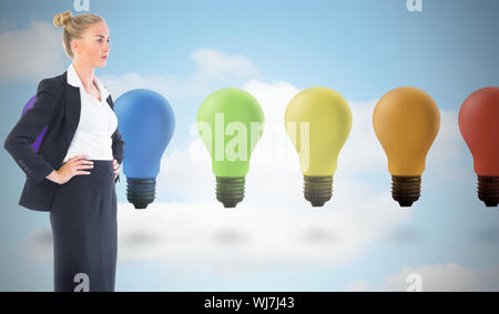 Composite image of blonde businesswoman standing with hands on hips Stock Photo