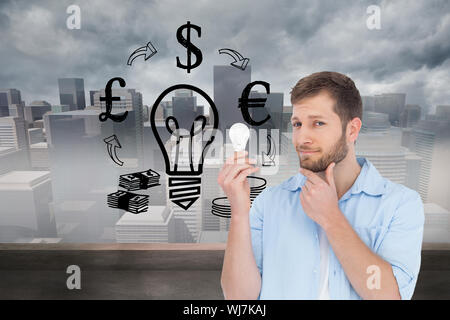 Composite image of handsome model holding a bulb Stock Photo