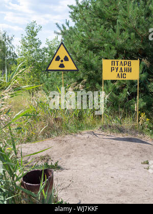 Red forest (Pripyat, Ukraine) limit sign in 2019. Next to it -- Ionizing radiation sign Stock Photo