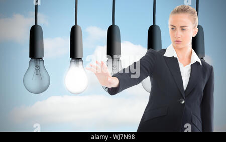 Composite image of blonde businesswoman pointing somewhere Stock Photo