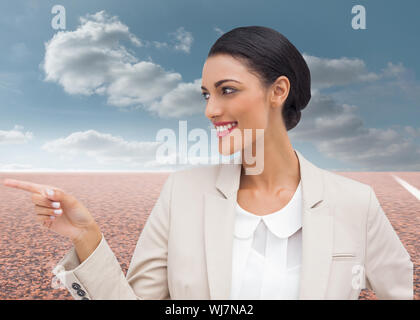 Composite image of smiling businesswoman pointing Stock Photo