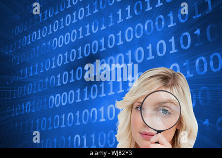 Composite image of fair-haired woman looking through a magnifying glass Stock Photo