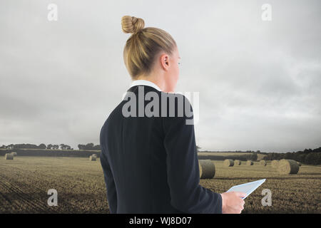 Composite image of blonde businesswoman holding tablet Stock Photo