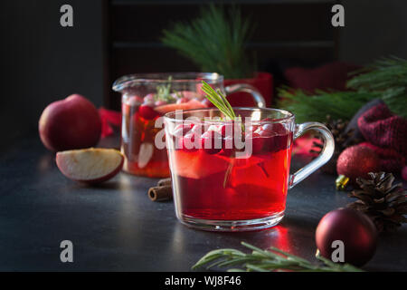 Christmas cranberry and apple mulled wine garnish rosemary and fir branches on black. Close up. Xmas drink. Stock Photo