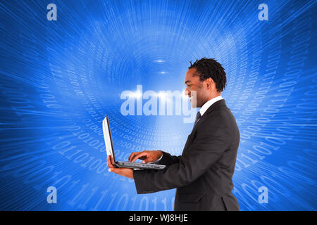 Composite image of smiling businessman working on laptop Stock Photo