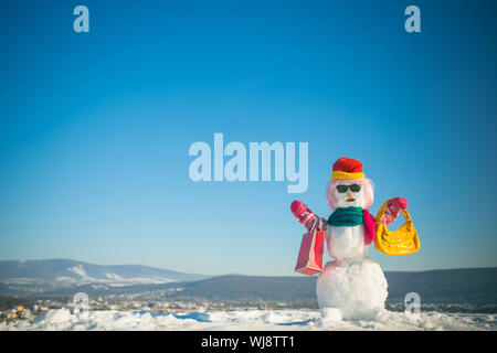 Snowman in pink wig, mittens, hat, glasses and scarf. Stock Photo