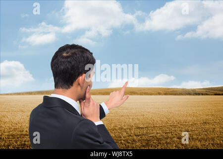 Composite image of thoughtful asian businessman pointing Stock Photo