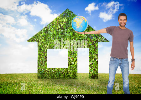 Composite image of handsome man holding out a globe Stock Photo