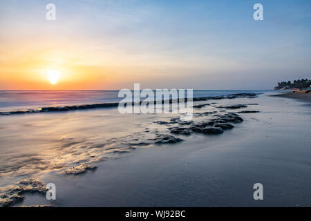 Seascape horizon with rocks in the water and ocean waves at sunrise on Cabarete beach, Dominican Republic Stock Photo
