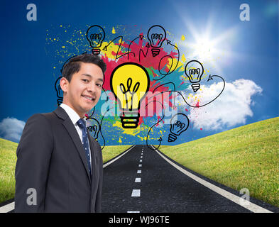 Composite image of colourful light bulbs graphic on bright countryside Stock Photo