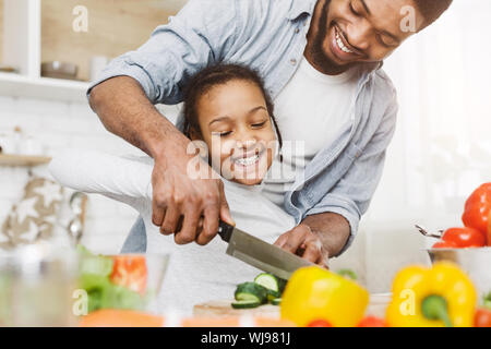 Cropped image of black father and dughter making salad Stock Photo
