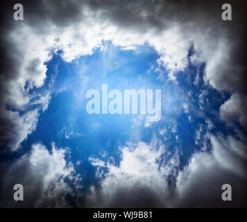 dramatic cloudscape with dark clouds and blue sky hole Stock Photo