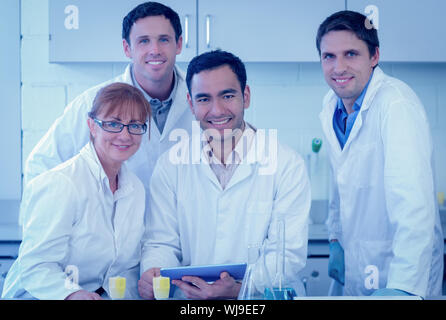 Group portrait of smiling scientists with tablet PC in the laboratory Stock Photo