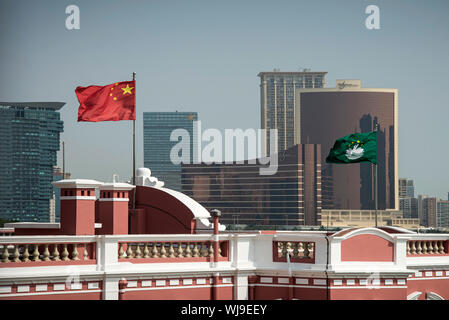 china and macau flags on chinese government headquarters building in downtown macau city Stock Photo