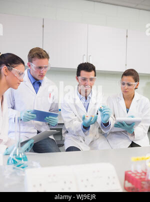 Group of scientists with tablet PC working on an experiment at the laboratory Stock Photo