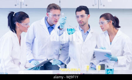 Group of scientists with tablet PC working on an experiment at the laboratory Stock Photo
