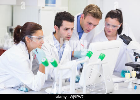 Group of scientific researchers looking at computer screen in the laboratory Stock Photo
