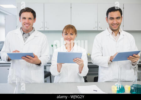 Group of smiling scientists using tablet PCs in the laboratory Stock Photo