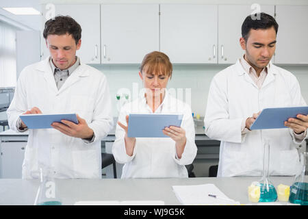 Group of serious scientists using tablet PCs in the laboratory Stock Photo
