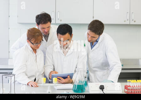 Group of serious scientists using tablet PC in the laboratory Stock Photo