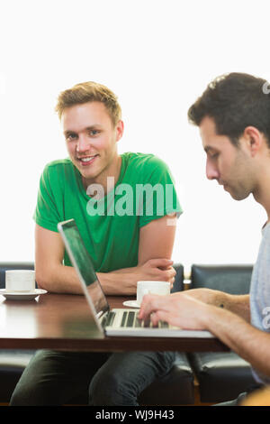 Two male students using laptop while having coffee at  the coffee shop Stock Photo
