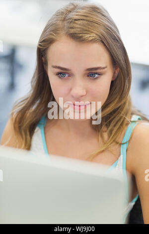 Focused pretty student working on computer in computer room at college Stock Photo