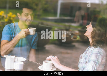 Two students laughing having a cup of coffee in college canteen Stock Photo