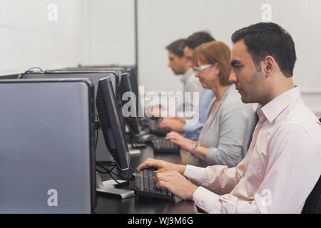 Mature students sitting in computer class working on computers Stock Photo
