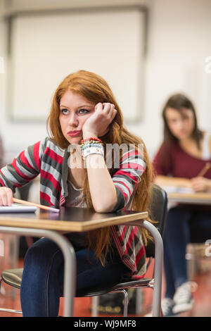 Bored young female student sitting in the classroom Stock Photo