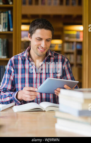 Smiling mature male student using tablet PC in the library Stock Photo