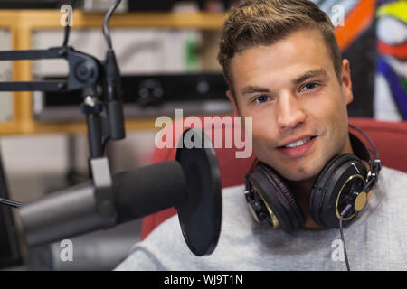 Handsome smiling singer recording a song in studio at college Stock Photo