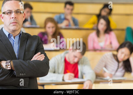 Portrait of an elegant teacher with students sitting at the college lecture hall Stock Photo