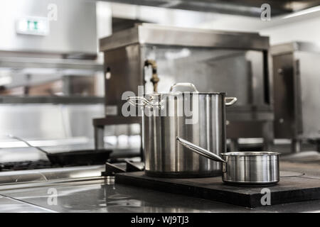Pots standing on hotplate in professional kitchen Stock Photo