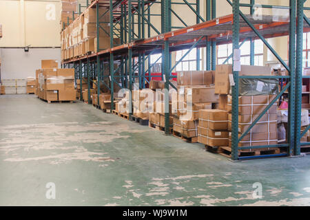 Rows of shelves with cardboard boxes in modern warehouse Stock Photo ...