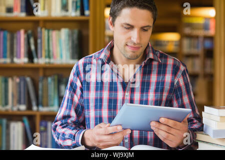 Concentrated mature male student looking at tablet PC in the library Stock Photo