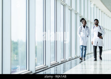 Two doctors discussing diagnosis while walking Stock Photo