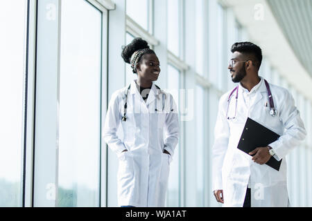 Two doctors discussing diagnosis while walking Stock Photo